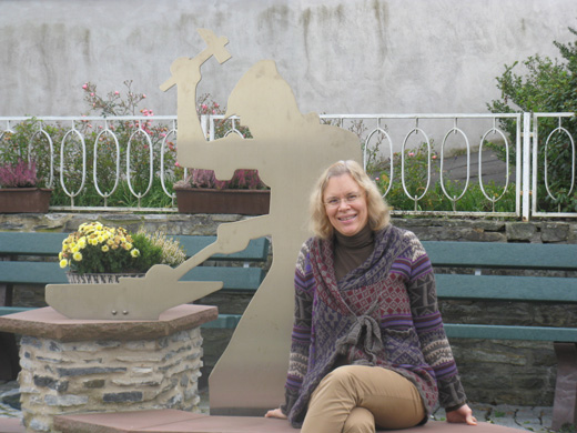 Die Autorin an einem Brunnen vor einer Schmied-Figur